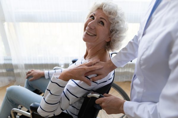 Happy,Middle,Aged,Handicapped,Woman,Sitting,In,Wheelchair,,Looking,At