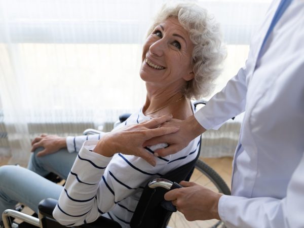 Happy,Middle,Aged,Handicapped,Woman,Sitting,In,Wheelchair,,Looking,At